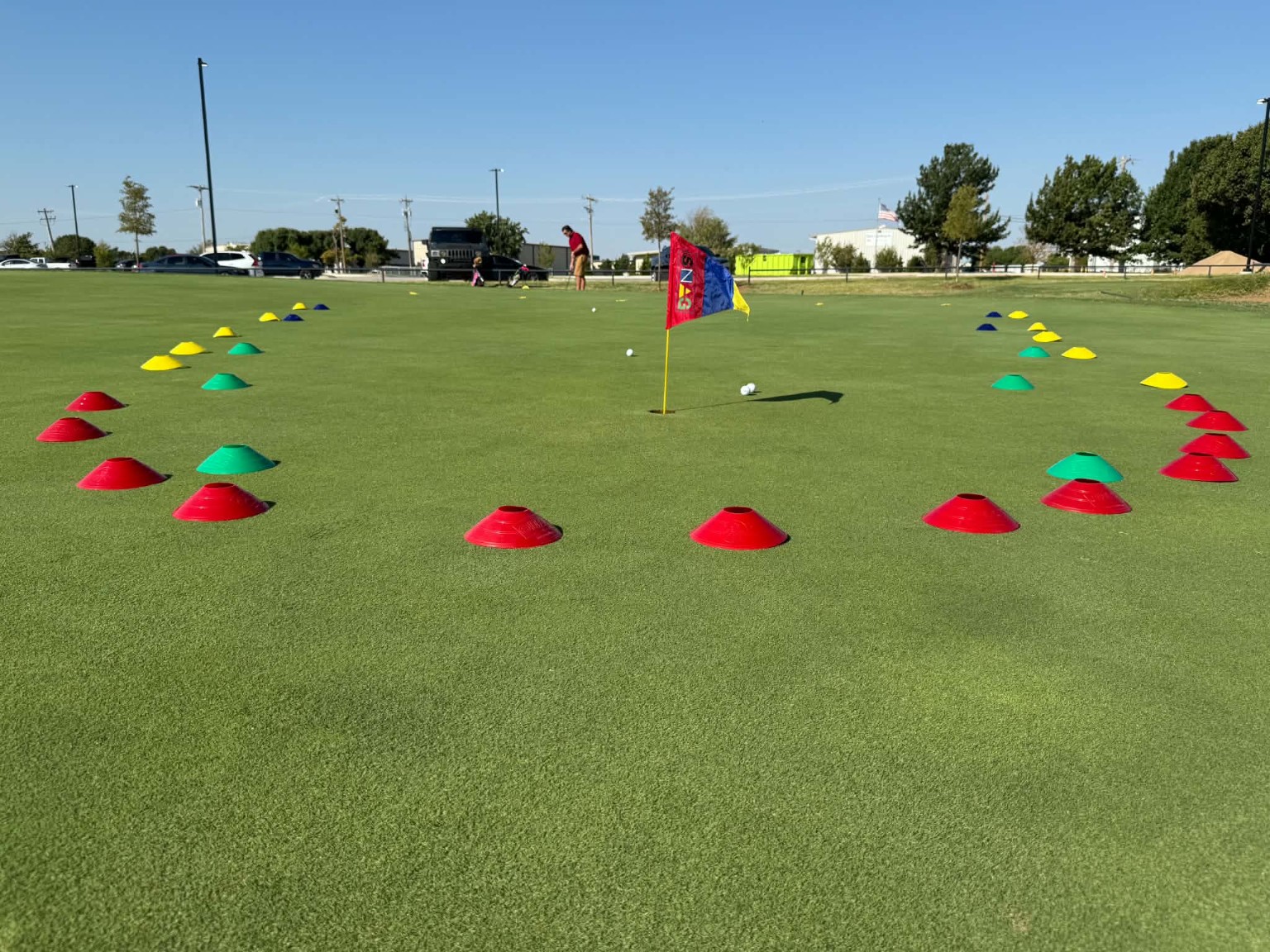 Colorful training cones arranged around a golf hole for putting challenges